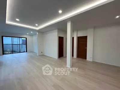 Spacious modern living room with sleek wooden flooring and recessed lighting