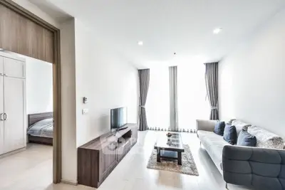 Modern living room with sleek furniture and natural light, adjacent to a cozy bedroom.