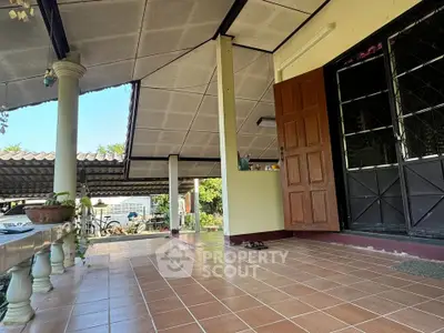 Charming home entrance with tiled patio and open door inviting you in.