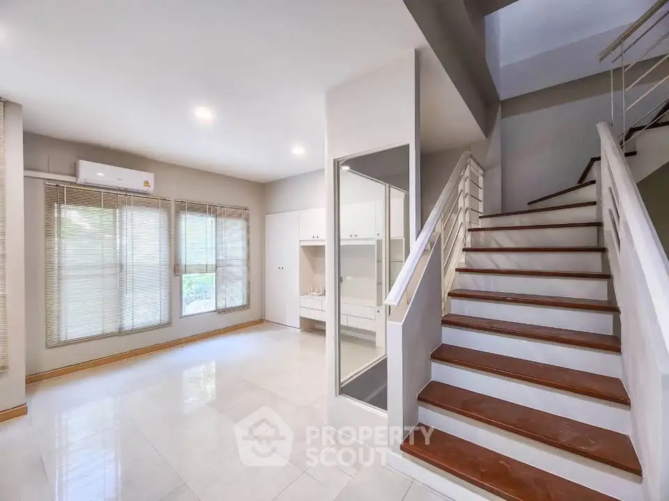Spacious modern living room with elegant staircase and natural light