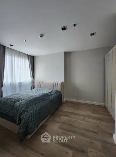 Spacious bedroom with modern decor and natural light