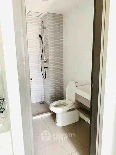Modern bathroom with sleek shower and toilet in a compact space.