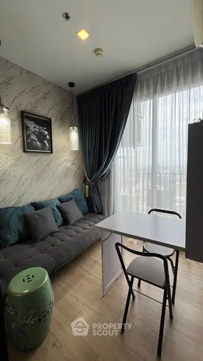 Modern living room with stylish decor and natural light, featuring a cozy sofa and dining area.