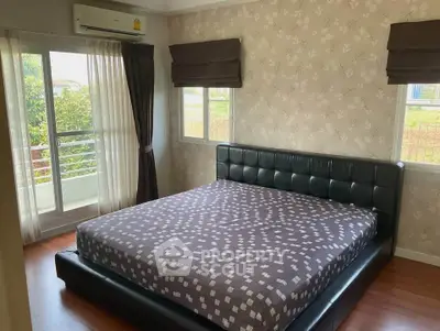 Spacious bedroom with large bed and natural light from balcony access.