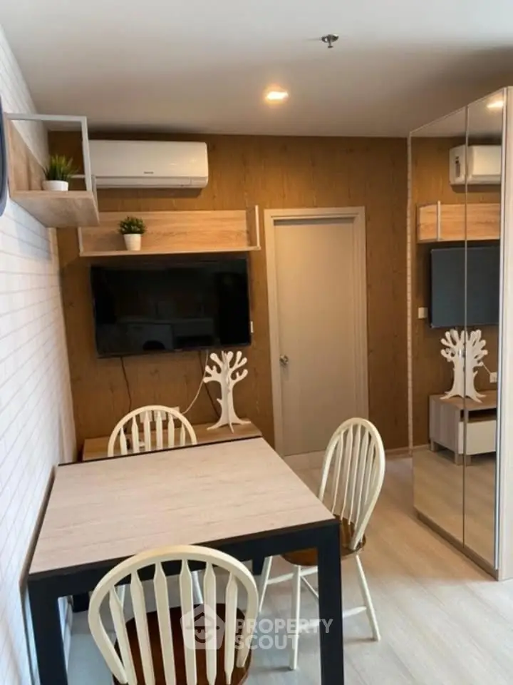 Modern dining area with wooden accents and wall-mounted TV in cozy apartment.