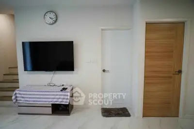 Modern living room with wall-mounted TV and wooden door