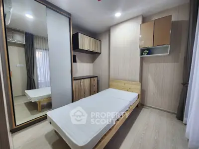 Cozy bedroom with wooden furnishings, large mirror wardrobe, and ample natural light, perfect for modern living.