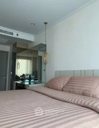 Modern bedroom with stylish decor and mirrored accents in a luxury apartment.
