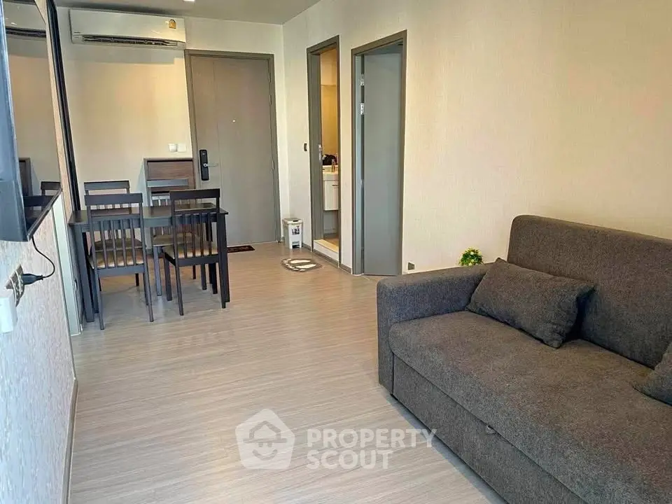 Modern living room with cozy sofa and dining area in stylish apartment.