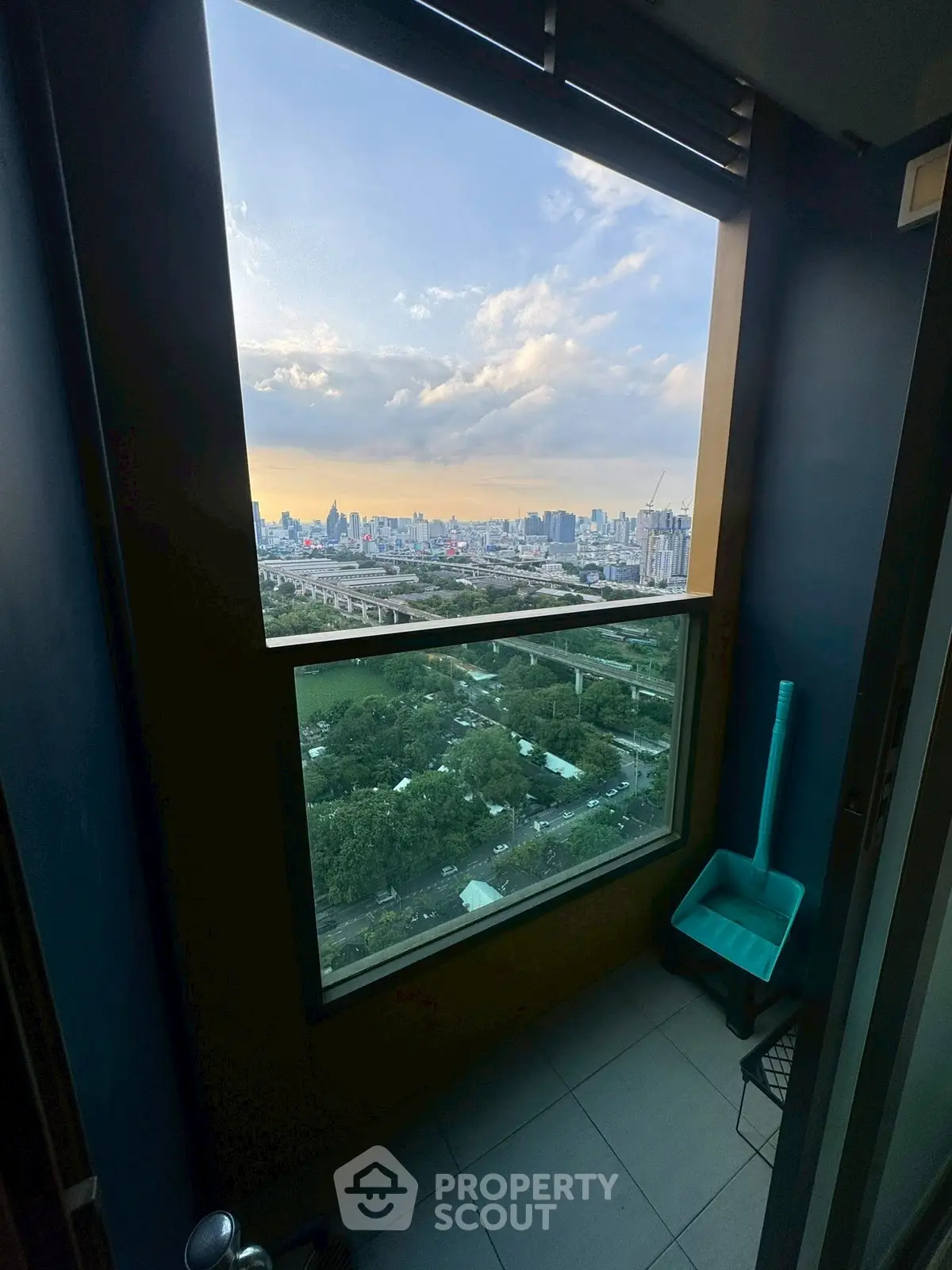 Stunning high-rise balcony view of city skyline at sunset.