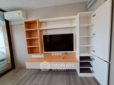 Modern living room with sleek built-in TV unit and ample storage space.