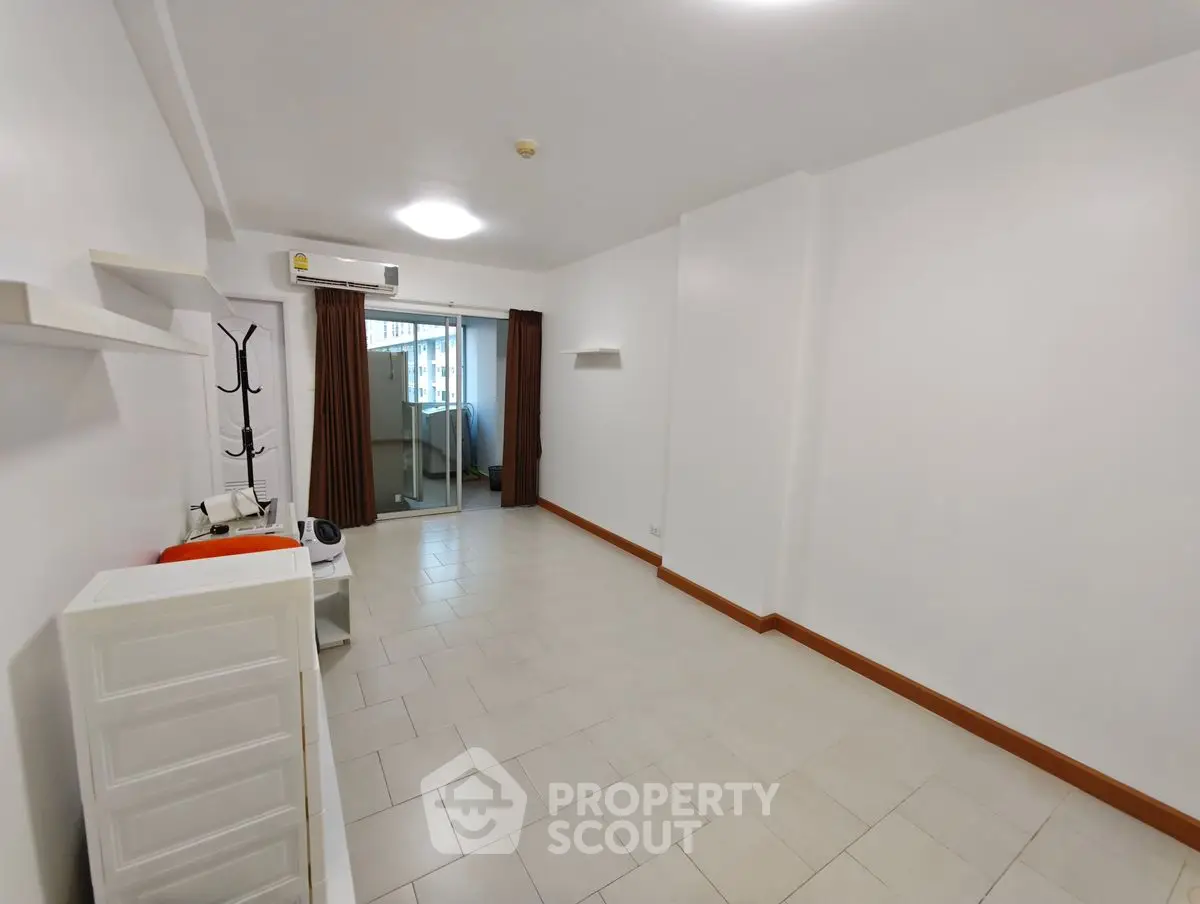 Spacious unfurnished room with tiled flooring and sliding glass doors leading to a balcony.