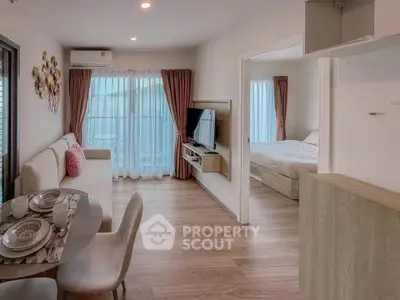 Modern open-plan living room with dining area and bedroom, featuring elegant decor and natural light.