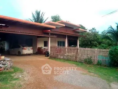 Charming rural home with spacious driveway and lush greenery, perfect for serene living.