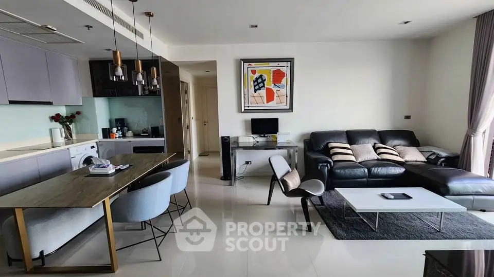 Modern open-plan living room with sleek kitchen and stylish dining area in a contemporary apartment.