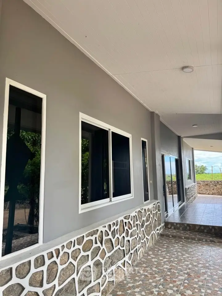 Charming exterior view of modern home with stone accents and spacious walkway.