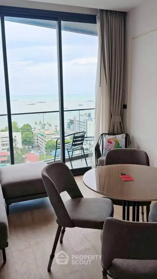 Modern living room with stunning ocean view and elegant furniture in high-rise apartment.