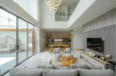 Luxurious open-plan living room with modern decor and large windows in a contemporary home.