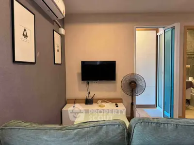 Cozy living room with wall-mounted TV, air conditioning, and modern decor.