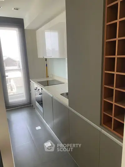 Modern compact kitchen with sleek cabinetry and built-in appliances, perfect for urban living.