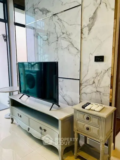Elegant living room with marble accent wall and stylish TV setup
