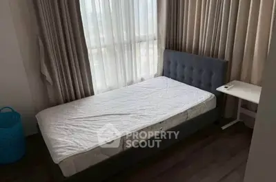 Cozy bedroom with single bed and large window offering natural light.