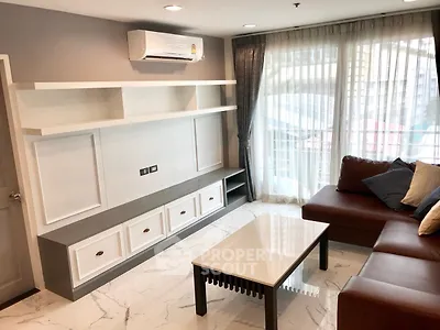 Modern living room with sleek furniture and large windows offering natural light.