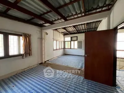 Spacious room with large windows and striped flooring, ideal for customization.