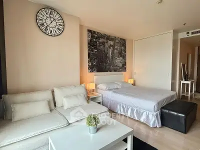 Modern bedroom with stylish decor, featuring a cozy bed, elegant sofa, and chic wall art.