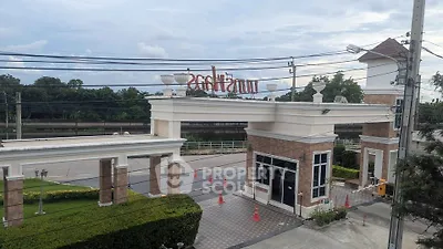 Elegant gated entrance of a residential community with lush greenery and modern design.