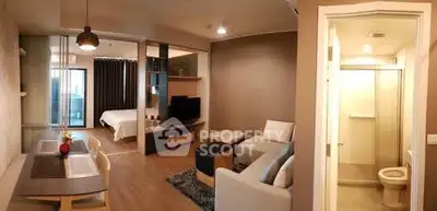 Modern open-layout apartment with cozy living area and bedroom, featuring stylish decor and natural light.