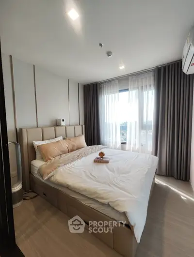 Modern bedroom with large window and stylish decor in a high-rise apartment.