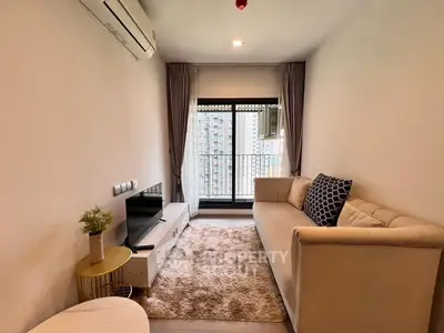 Modern living room with cozy sofa and city view from balcony in high-rise apartment.