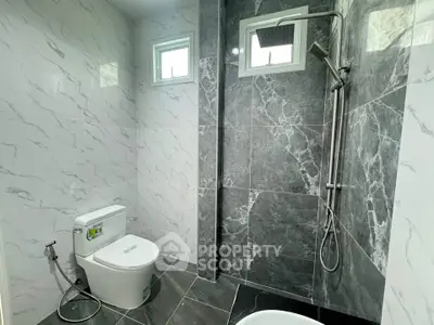 Modern bathroom with sleek marble tiles and rainfall showerhead