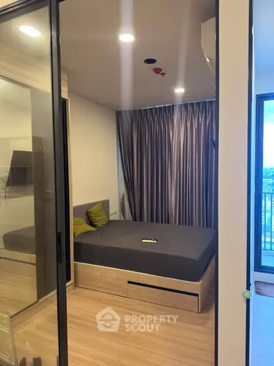 Modern bedroom with sleek design and large windows offering natural light and a cozy atmosphere.