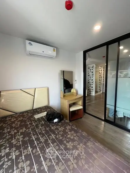 Modern bedroom with stylish decor and sliding glass doors in a contemporary apartment.