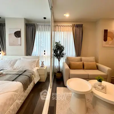 Modern bedroom with cozy seating area and stylish decor, featuring large windows and elegant furnishings.