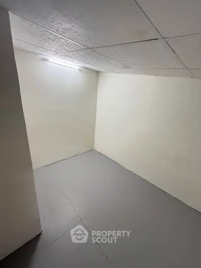 Minimalist storage room with white walls and gray floor, ideal for organizing.