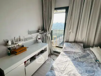 Cozy bedroom with balcony offering stunning city view, modern decor, and ample natural light.