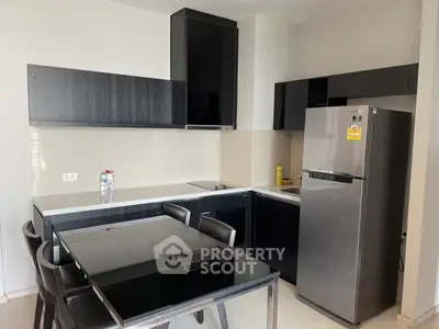 Modern kitchen with sleek black cabinets and stainless steel fridge