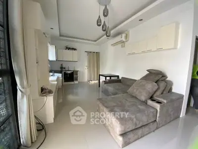 Spacious modern living room with plush gray sectional sofa and sleek white cabinetry.