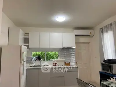 Modern kitchen with sleek cabinetry and air conditioning, featuring a large window for natural light.