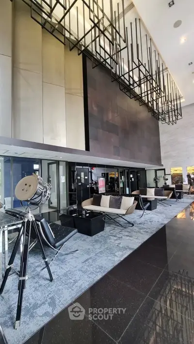 Luxurious modern building entrance with stylish seating and unique lighting fixtures.