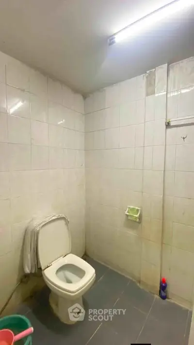 Simple bathroom with tiled walls and basic fixtures