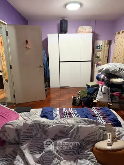 Cozy bedroom with modern wardrobe and vibrant decor, perfect for a comfortable living space.