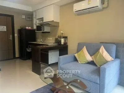 Modern studio apartment with cozy living area and compact kitchen, featuring air conditioning and stylish decor.