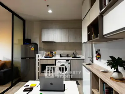 Modern kitchen with sleek cabinetry, washing machine, and open layout design.