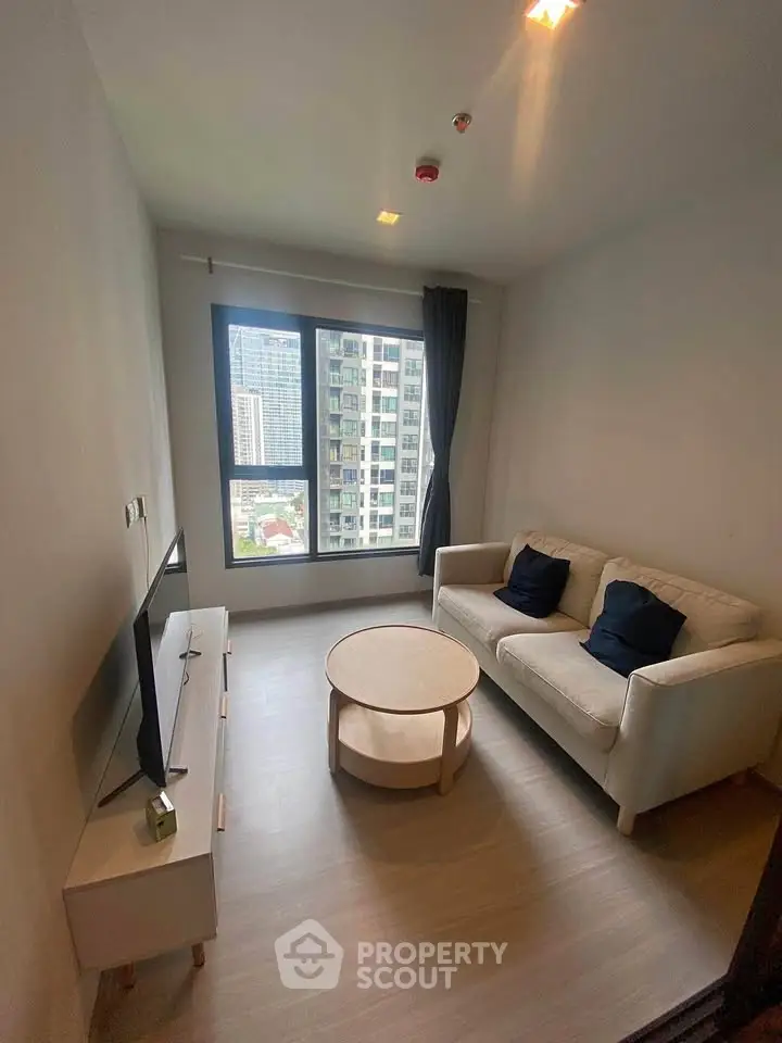 Cozy living room with modern sofa and city view window in urban apartment.