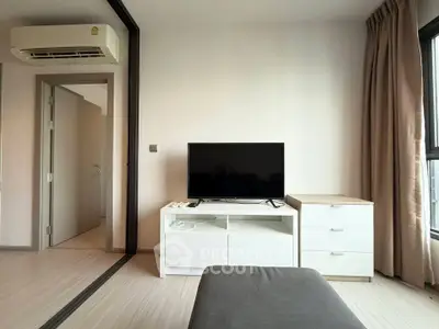 Modern living room with sleek TV setup and stylish furniture in a bright apartment.