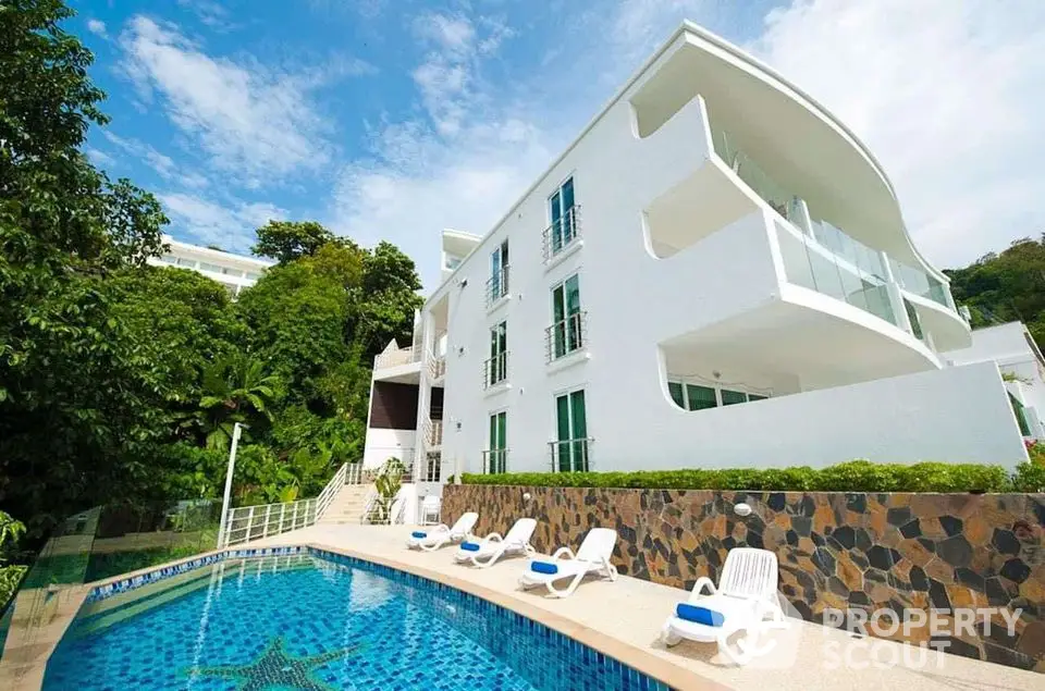 Stunning modern white building with pool and lush greenery, perfect for luxury living.